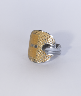 Aluminium key bent into a ring, two rectangular areas and the structured surface are filled with golden enamel