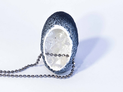 Necklace with a black silk cocoon pendant whose white inside is filled with small glass balls, the chain is made of silver