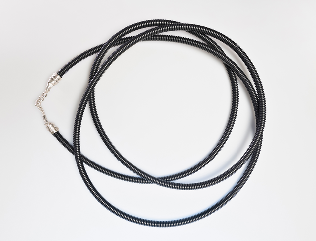 Long necklace made of black protective tube with cast silver clasps