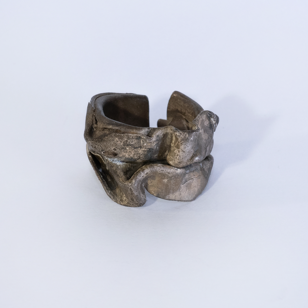 Curved open silver ring with brownish patina that looks like a thick crushed foil