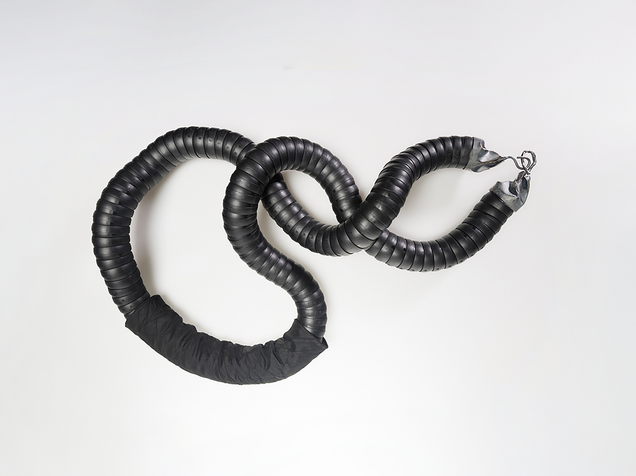 Heavy chain in black flexible industrial hose with cast silver clasps and silk fabric
