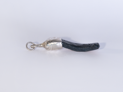 Pendant made of an elongated black glazed ceramic piece with a silver cap, the glaze "Fat Lava" looks like the surface of the moon
