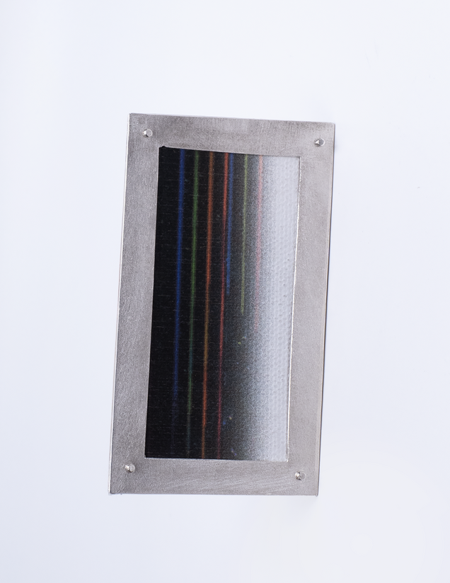Unregelmäßig eckige Brosche mit einem Rahmen aus Silber und Leinwand in bunten feinen Streifen, sie sieht aus wie ein Bilderrahmen