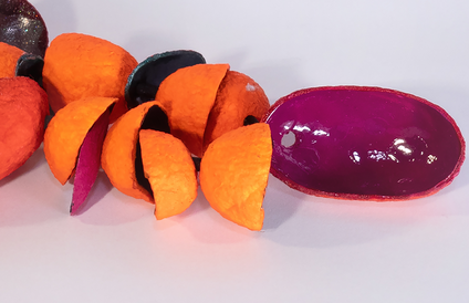 Viele offene Seidenkokons, die in Orangetönen bemalt sind, an einem schwarzen Seidenband