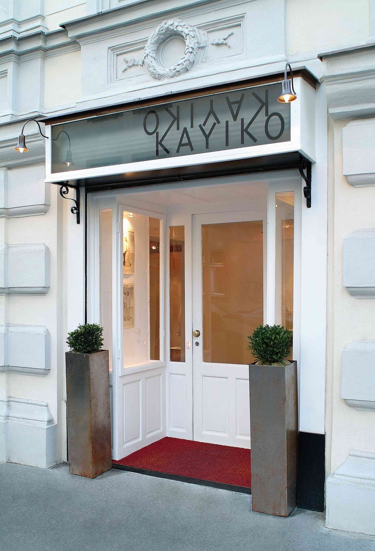 Weiße Fassade des Fashion Stores Kayiko Wien, über dem Türsturz sieht man das Schild KAYIKO