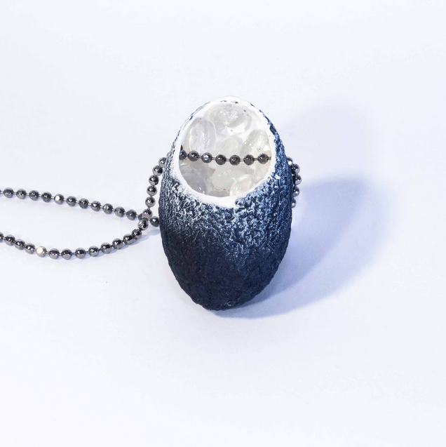 Necklace with a black silk cocoon pendant whose white inside is filled with small glass balls, the chain is made of silver