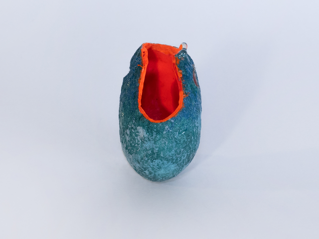 Pendant made of an open dark green silk cocoon, painted bright orange on the inside, on the outside are shiny drops