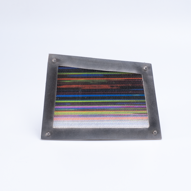Irregular angular brooch with a silver frame and canvas in colourful fine stripes, it looks like a framed picture