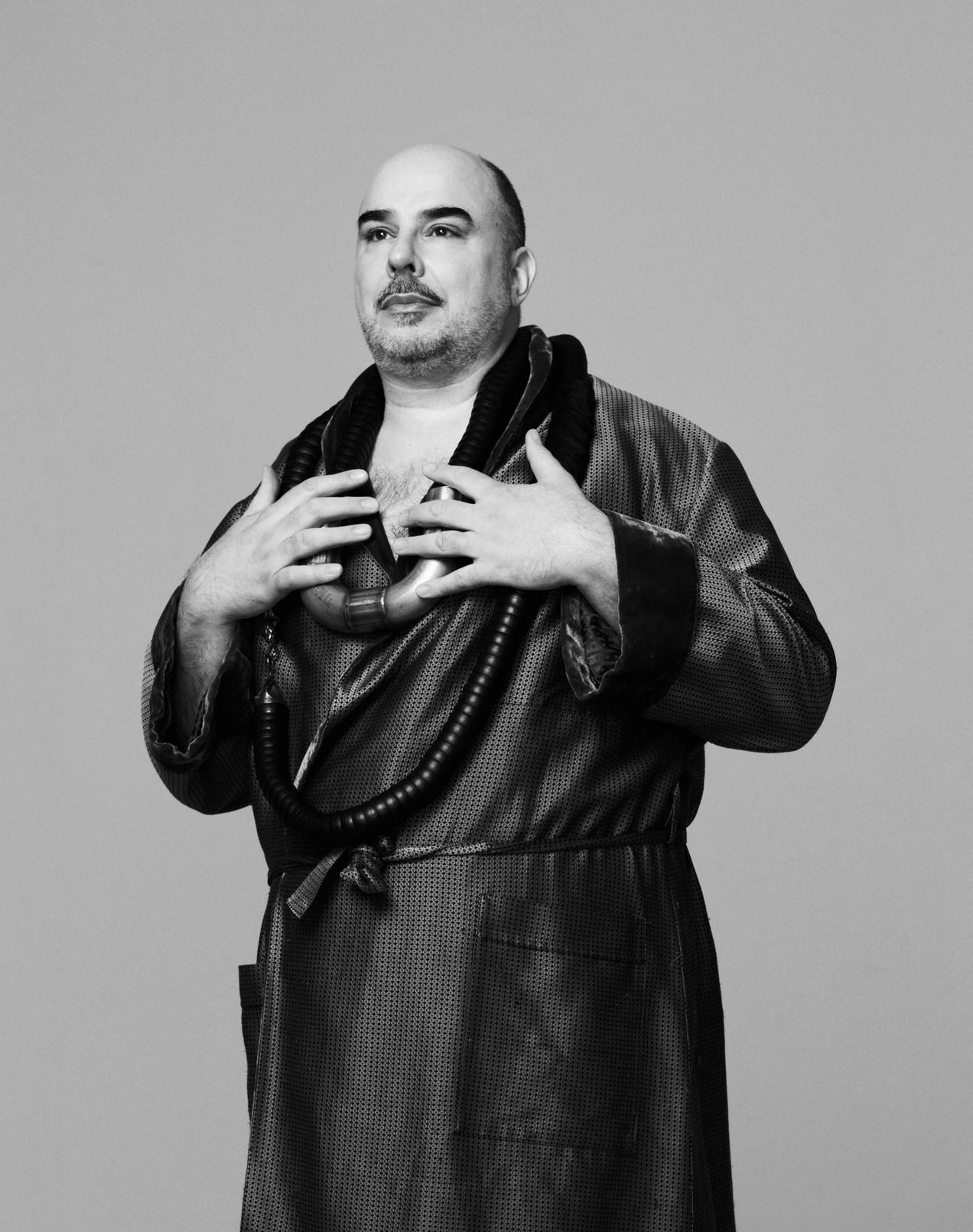 Actor Robert Joseph Bartl wears two heavy Brazil necklaces made from tubes and silver over a dark robe 