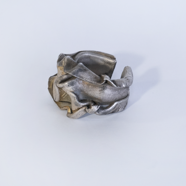 Curved open silver ring with brownish patina that looks like a thick crushed foil