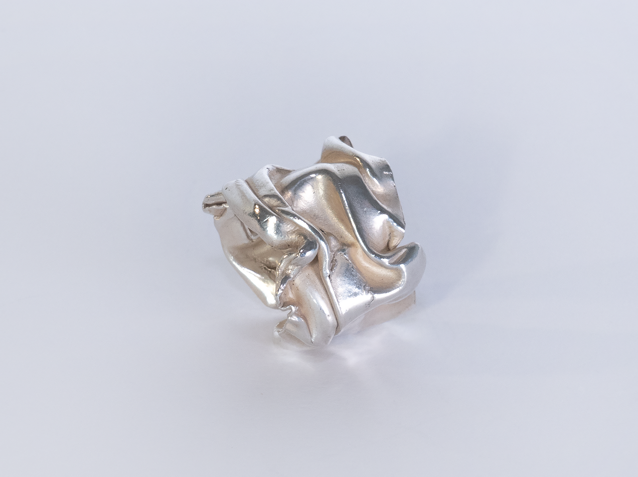 Curved open silver ring with that looks like a thick crushed foil