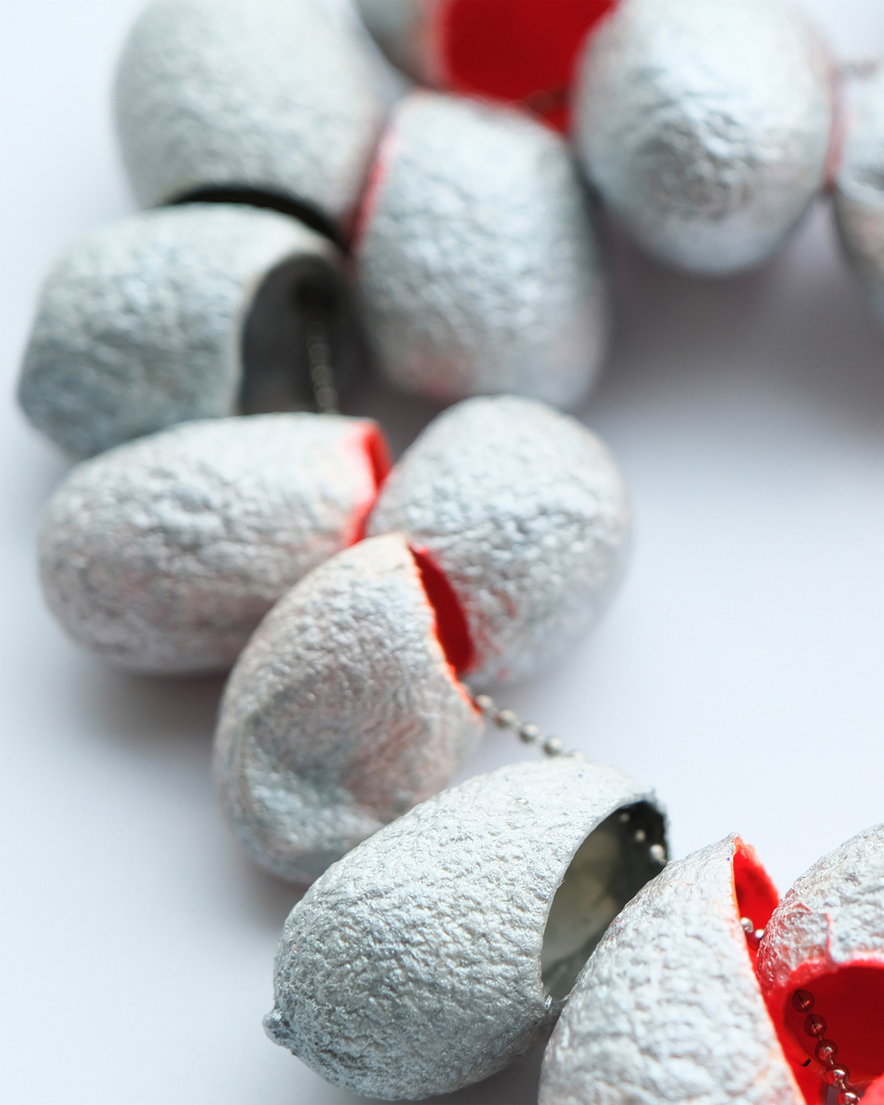 Long necklace made of 21 silk cocoons, bright orange inside, silver-coloured outside, on a thin stainless steel chain