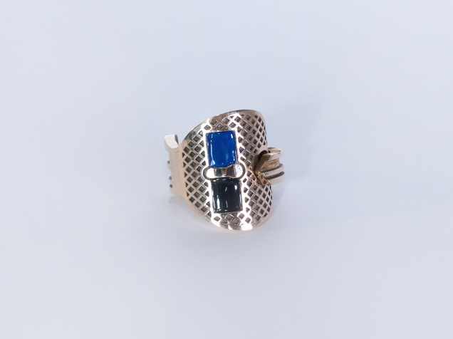 Bronze key bent into a ring, two rectangular areas are filled with dark blue and black enamel