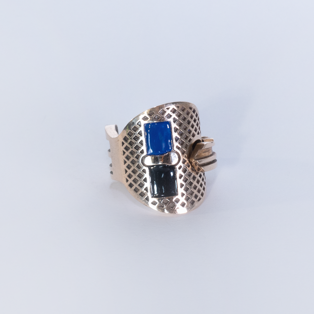 Bronze key bent into a ring, two rectangular areas are filled with dark blue and black enamel