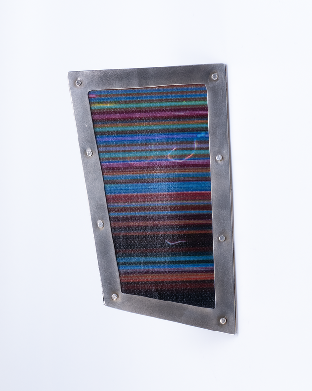 Unregelmäßig eckige Brosche mit einem Rahmen aus Silber und Leinwand in bunten feinen Streifen, sie sieht aus wie ein Bilderrahmen