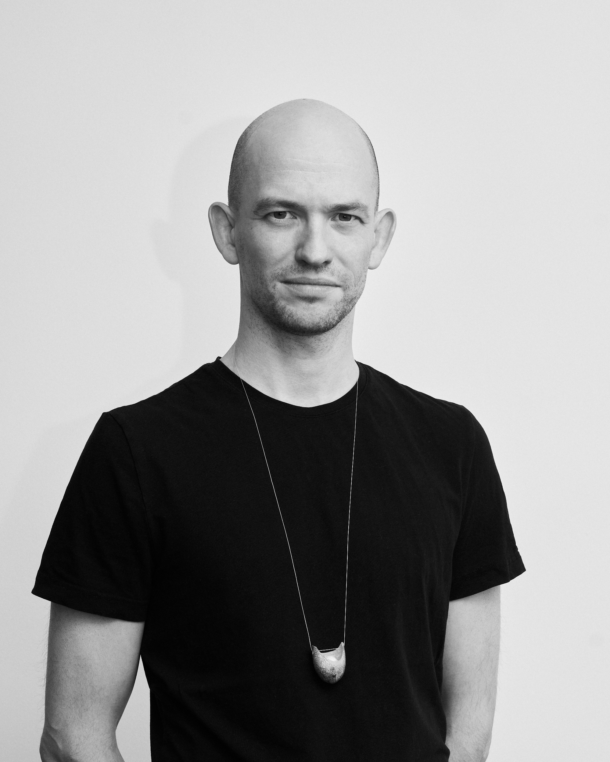 Künstler Nick Oberthaler mit einer Kette aus der FUSION Kollektion über einem schwarzen Shirt